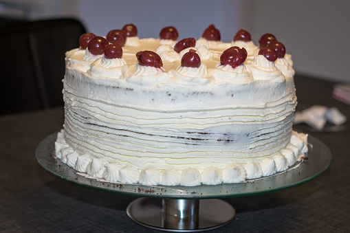 Schwarzwalder kirsch cake (Black Forest cake) decorated with whipped cream and cherries.