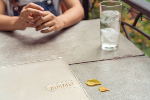 Outdoors romantic summer dinner date with menu on rustic table