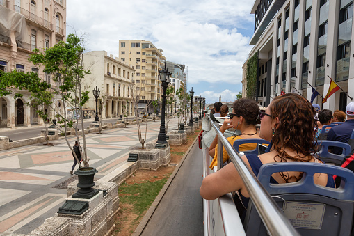 Havana, Cuba - May 23, 2019: View from a Touristic Bus Tour, Hop on Hop Off, in the streets of the Old Havana City during a vibrant and bright sunny day.