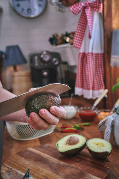 istock Cutting Avocado on Wooden Cutting Board 1160056610
