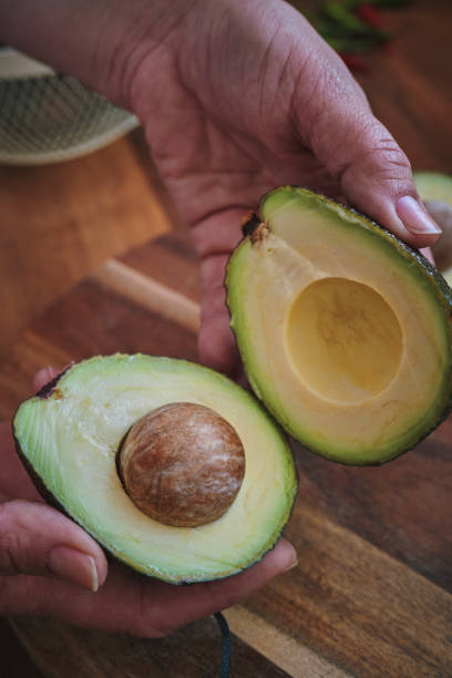 istock Cutting Avocado on Wooden Cutting Board 1160056626