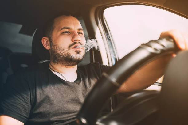 conduciendo con un cigarrillo en la mano, un hombre fumando al volante - car speed lifestyles night fotografías e imágenes de stock