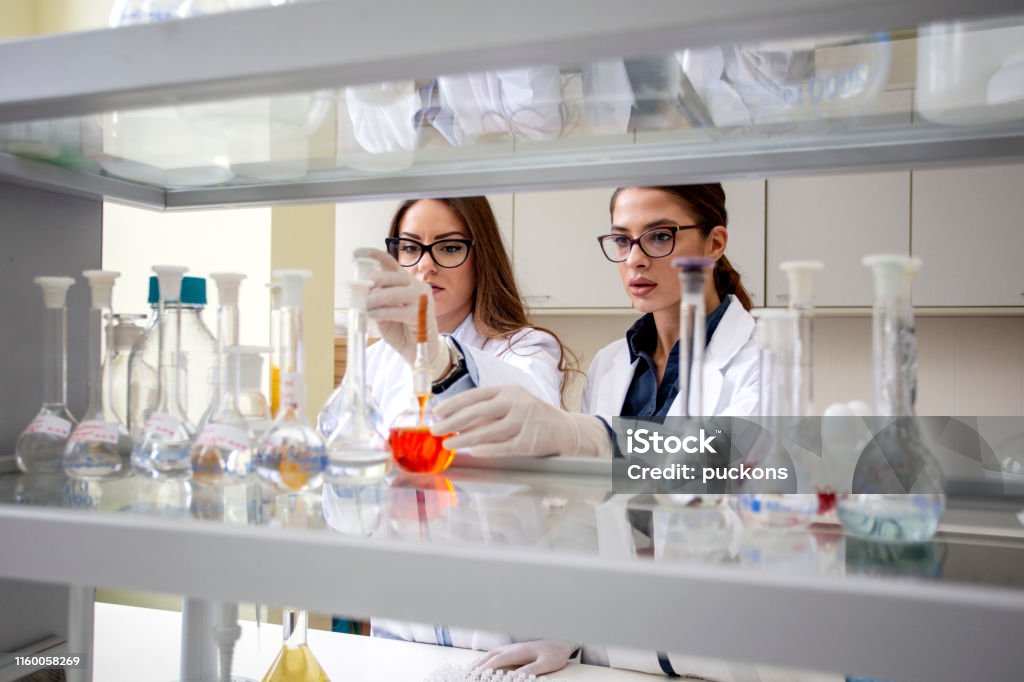 Two young woman work in laboratory on analyze Adult Stock Photo