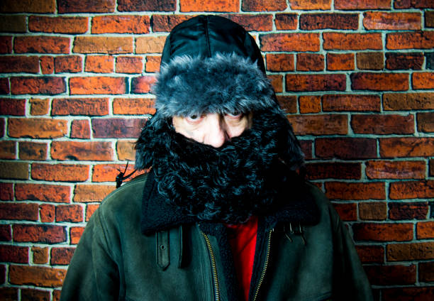 istock Steampunk man with backpack, beard, hat and glasses on background of vintage brick wall 1160058320