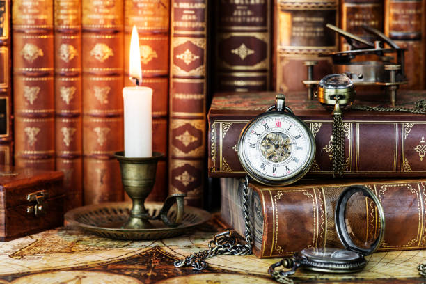 istock Pocket watch, burning candle and old books 1160061816