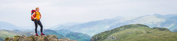 istock Young woman hiker standing on mountain looking at panoramic view 1160061973