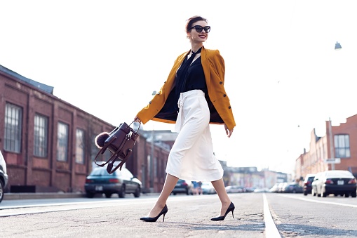 Full photo of stylish happy young business woman walking on the street