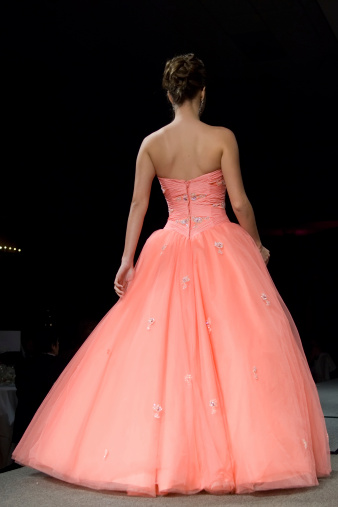brunette young female modeling in a catwalk in a pink sweet sixteen dress