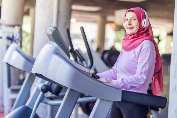 istock muslim woman running on treadmill looking at camera 1160065120
