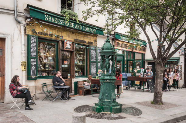 Tourists outside famous Shakespeare and company bookstore. Paris - July 11th 2014: Tourists outside famous Shakespeare and company bookstore.  Place know for receiving visits from Ernest Hemingway, Ezra Pound, F. Scott Fitzgerald, Gertrude Stein and James Joyce. william shakespeare photos stock pictures, royalty-free photos & images