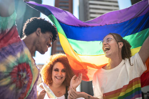 grupo de amigos disfrutando del desfile lgbtqi - gay pride rainbow flag homosexual fotografías e imágenes de stock