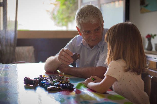 Grandfather and little granddaughter playing together. stock photo