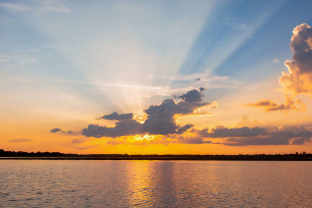istock Sunset reflection lagoon. beautiful sunset behind the clouds and blue sky above the over lagoon landscape background. dramatic sky with cloud at sunset 1160089307