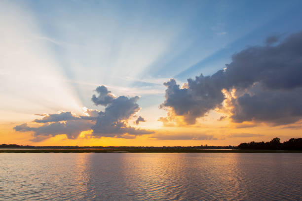 istock Sunset reflection lagoon. beautiful sunset behind the clouds and blue sky above the over lagoon landscape background. dramatic sky with cloud at sunset 1160089411