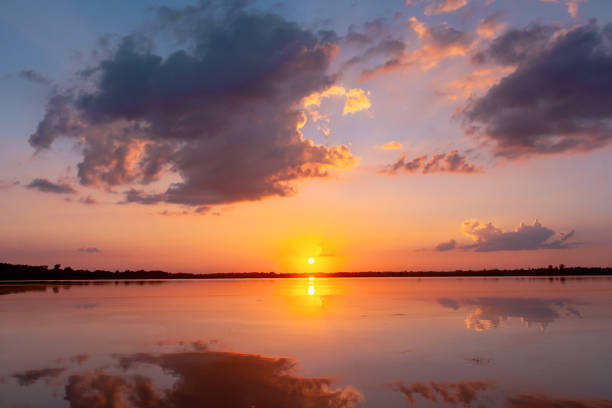 istock Sunset reflection lagoon. beautiful sunset behind the clouds and blue sky above the over lagoon landscape background. dramatic sky with cloud at sunset 1160089496