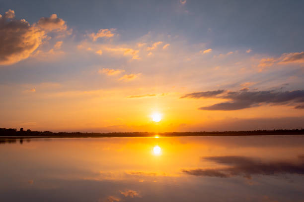 istock Sunset reflection lagoon. beautiful sunset behind the clouds and blue sky above the over lagoon landscape background. dramatic sky with cloud at sunset 1160091734