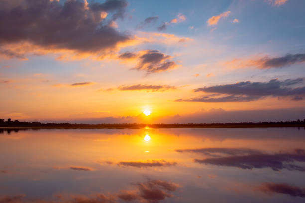 istock Sunset reflection lagoon. beautiful sunset behind the clouds and blue sky above the over lagoon landscape background. dramatic sky with cloud at sunset 1160091739