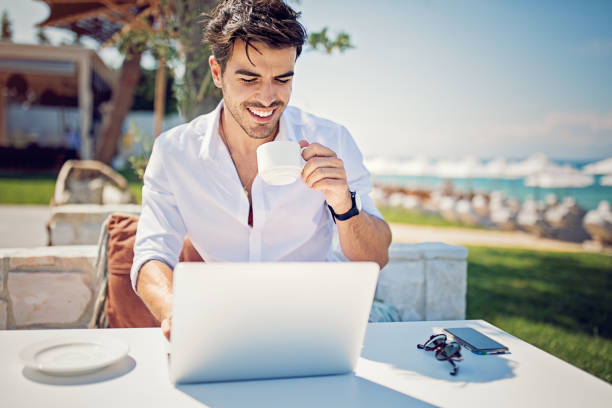 istock Young businessman is working and drinking coffee on the beach 1160097682