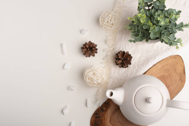 istock White porcelain teapot with accessories on a wooden board on a white table. View from above. Copy space 1160102131