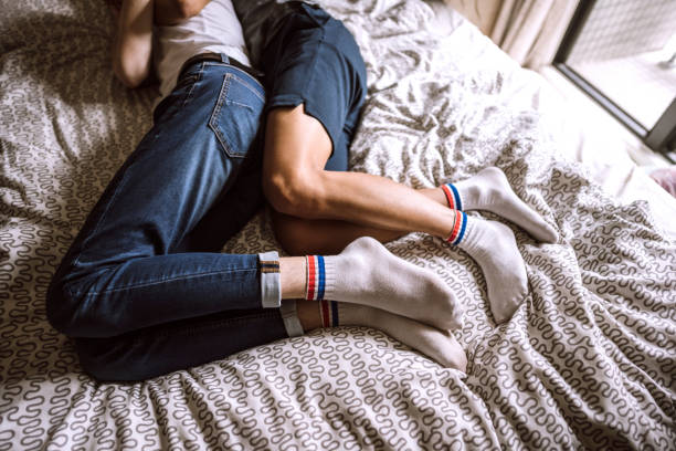 partner omosessuali che dormono a letto insieme - spooning love embracing men foto e immagini stock