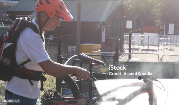 Mature Mountain Biker Cleans Bike At Bike Wash Station Stock Photo - Download Image Now