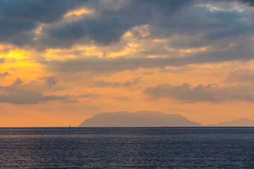 Picturesque sunset over Tyrrhenian Sea in Milazzo town, Sicily, Italy. Aeolian Islands (Italian: Isole Eolie), volcanic archipelago on the north of Sicily on the background
