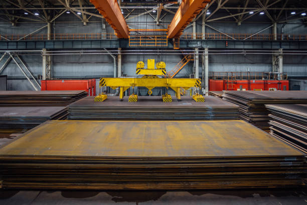 istock Overhead crane with magnetic grippers lifting steel sheets 1160105059