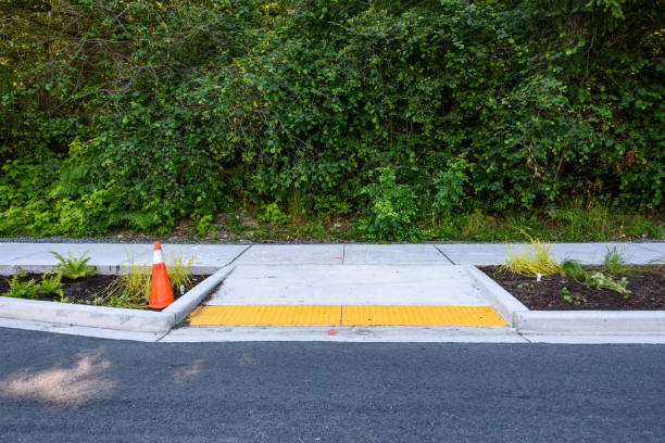 New sidewalk and planting Newly planted median between the street and new sidewalk, including disabled entrance ramp, ferns, ornamental grasses, other plants, and orange safety cone tennessee road sign stock pictures, royalty-free photos & images
