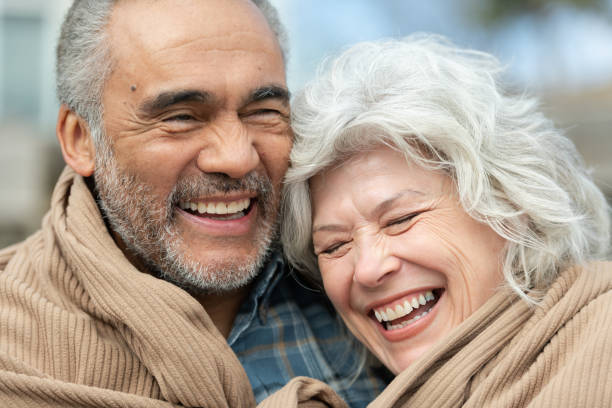 istock Senior couple wrapped in a blanket on a beach 1160108910