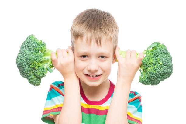 istock boy with broccoli, studio portrait on white background isolated 1160108917