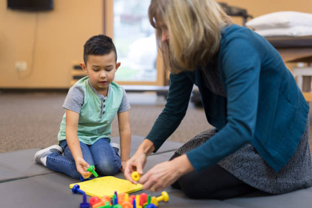 istock Occupational therapist works with a young ethnic boy 1160109169