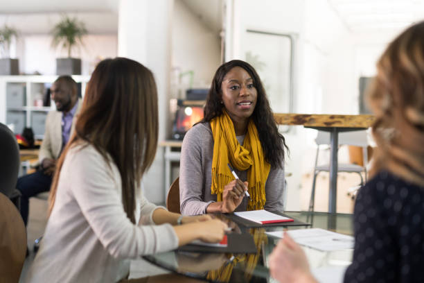 istock Female CEO leads a team meeting at the conference table 1160111511