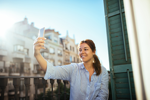 Young girl making a selfie on a balcony.