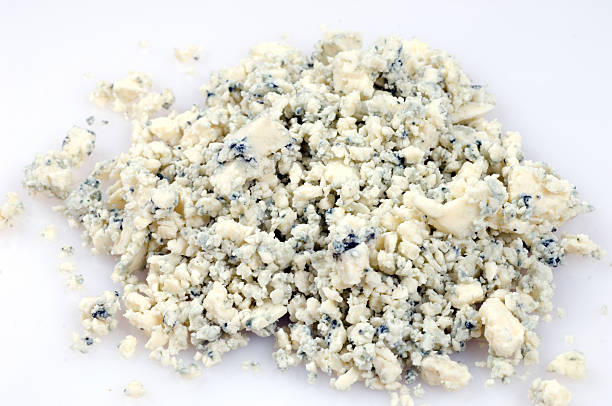 crumbled blue cheese crumbled aged blue cheese on white background blue cheese stock pictures, royalty-free photos & images