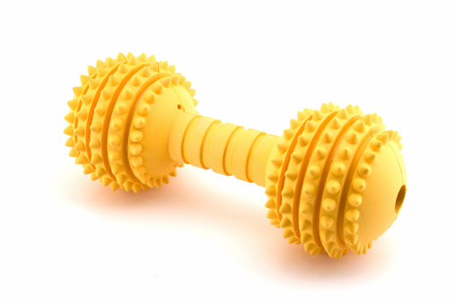 Yellow rubber dog toy. Ridges keep dogs teeth clean. Isolated on white with copy space.