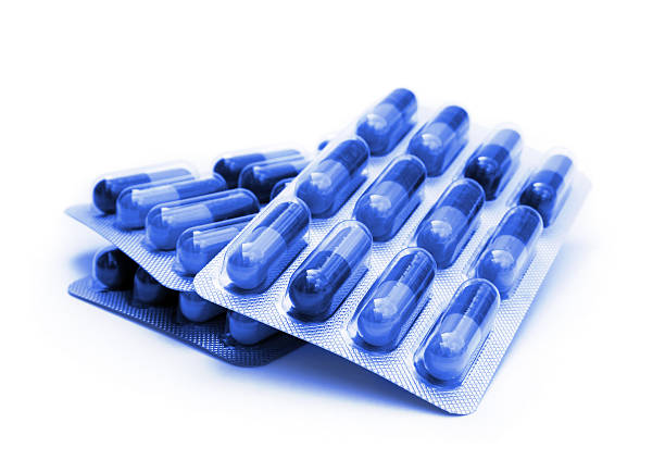 Three packs of blue capsule pills on a white background stock photo