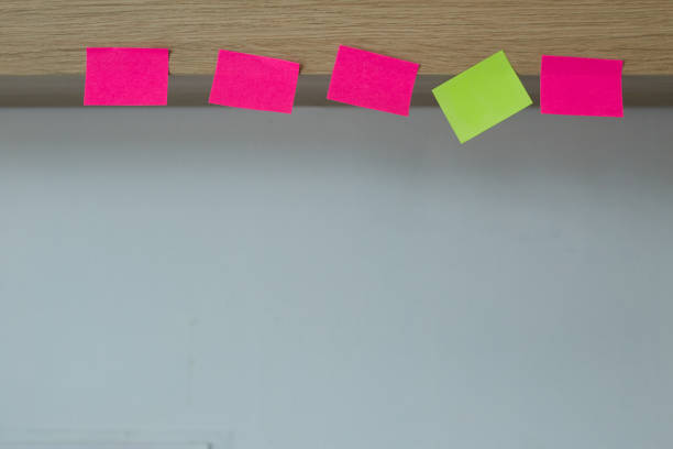istock Empty post it note stick on the wooden floor with white walls 1160125046