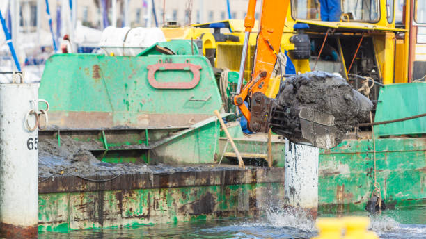 istock Excavator shovel digging in sand from water 1160127649