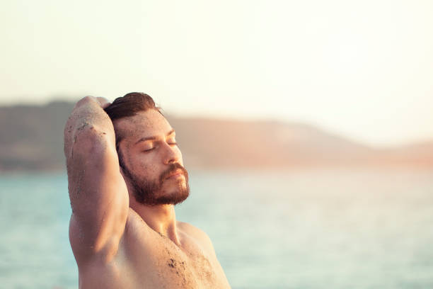 istock young handsome man on the beach in summer season 1160129585