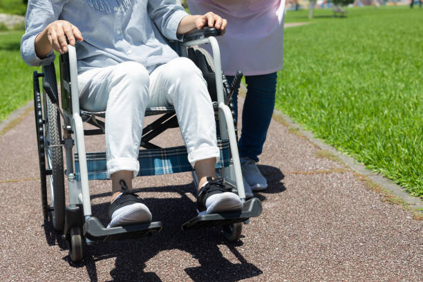 istock Senior and care helper taking a walk with a wheelchair 1160130480