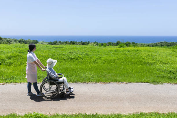 istock Senior and care helper taking a walk with a wheelchair 1160130484