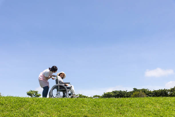 istock Senior and care helper taking a walk with a wheelchair 1160130504