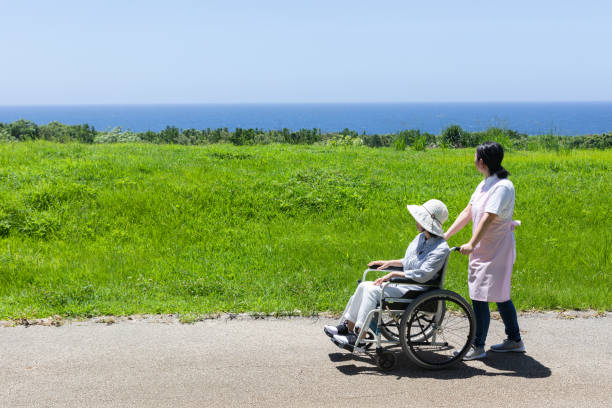 istock Senior and care helper taking a walk with a wheelchair 1160130523