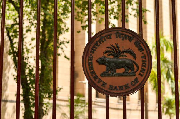 delhi, india, 2019. logo rbi sul cancello di ferro chiuso dell'edificio della reserve bank of india (rbi) a patel chowk, parliament road, connaught place con l'edificio per uffici sullo sfondo. - india indian culture business technology foto e immagini stock