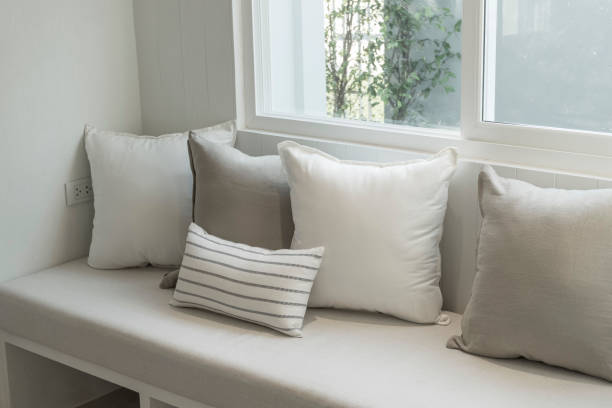 istock comfortable sofa with white and grey cushions by the window. 1160134400