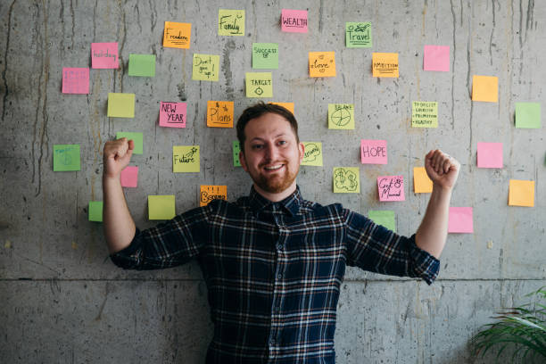 istock Happy man present his sticky notes chart on cement wall.  Entrepreneur concept 1160138374