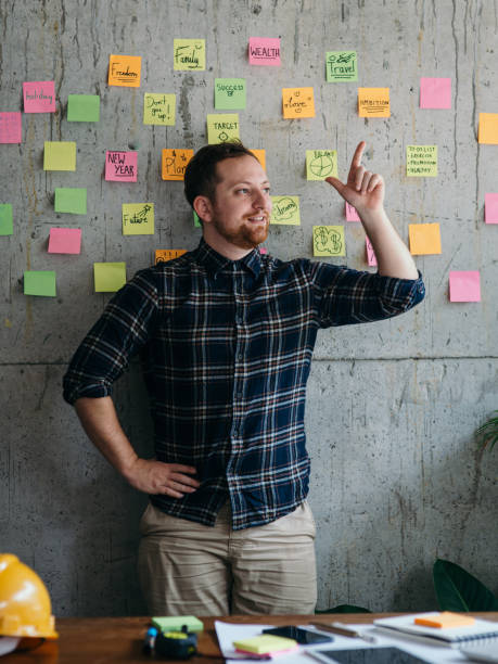 istock Happy engineer man present his sticky notes chart on cement wall.  Entrepreneur concept 1160140227