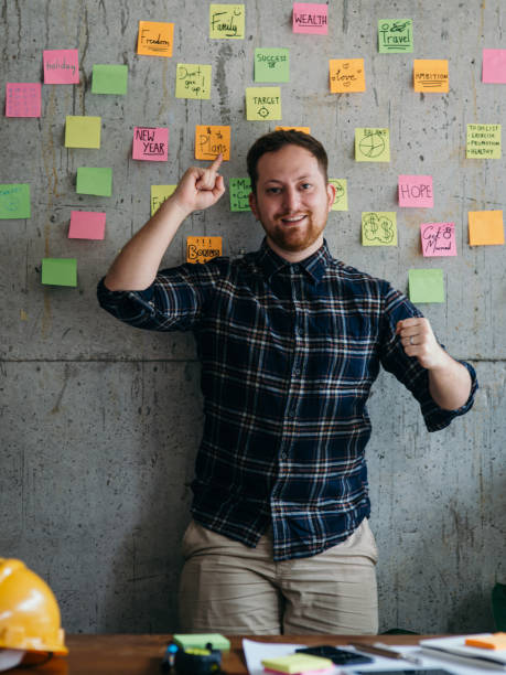 istock Happy engineer man present his sticky notes chart on cement wall.  Entrepreneur concept 1160140235
