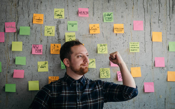 istock Happy engineer man present his sticky notes chart on cement wall.  Entrepreneur concept 1160140258