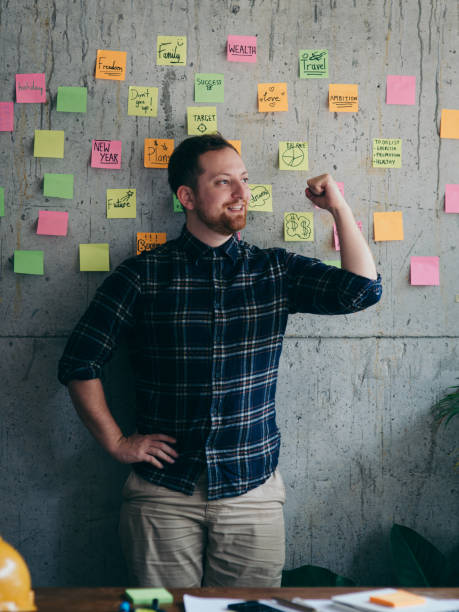 istock Happy engineer man present his sticky notes chart on cement wall.  Entrepreneur concept 1160140261
